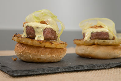 "Montadito" de minihamburguesa con salsa al curri, piña, cebolla crujiente y ensalada de apio