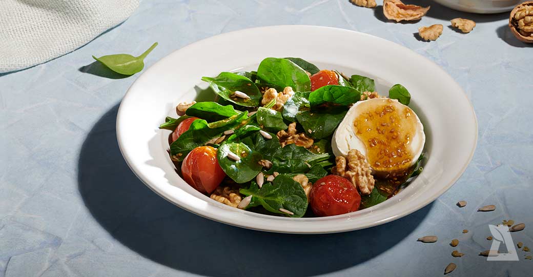 Ensalada de espinacas, queso de cabra, nueces y tomates confitados