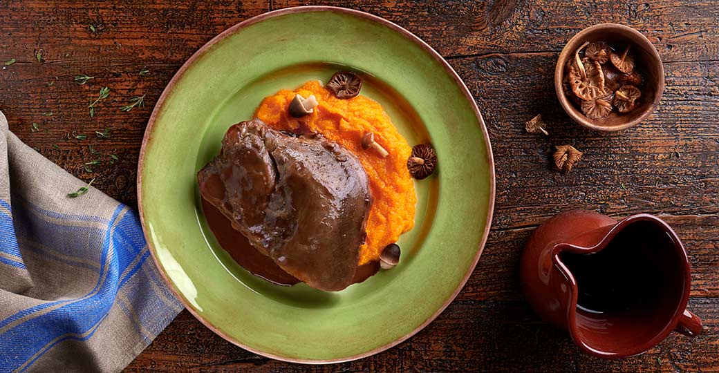 Carrillada de cerdo con salsa de vino sobre parmentier de calabaza y setas