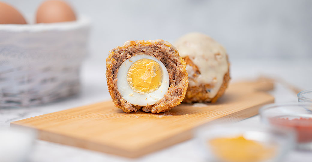 Huevos duros rebozados de carne picada de ternera y salsa de queso