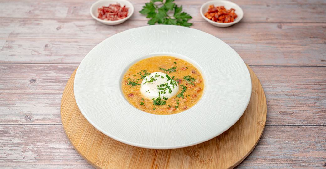Sopa de ajo, pan, chorizo y jamón ibérico con huevo poché