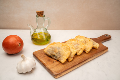 Crestes cruixents de botifarra, ceba caramel·litzada i formatge fresc