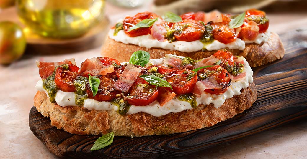 Torrada de burrata, cirerols saltats, pesto i bacó