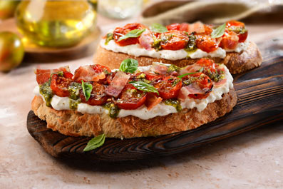 Torrada de burrata, cirerols saltats, pesto i bacó